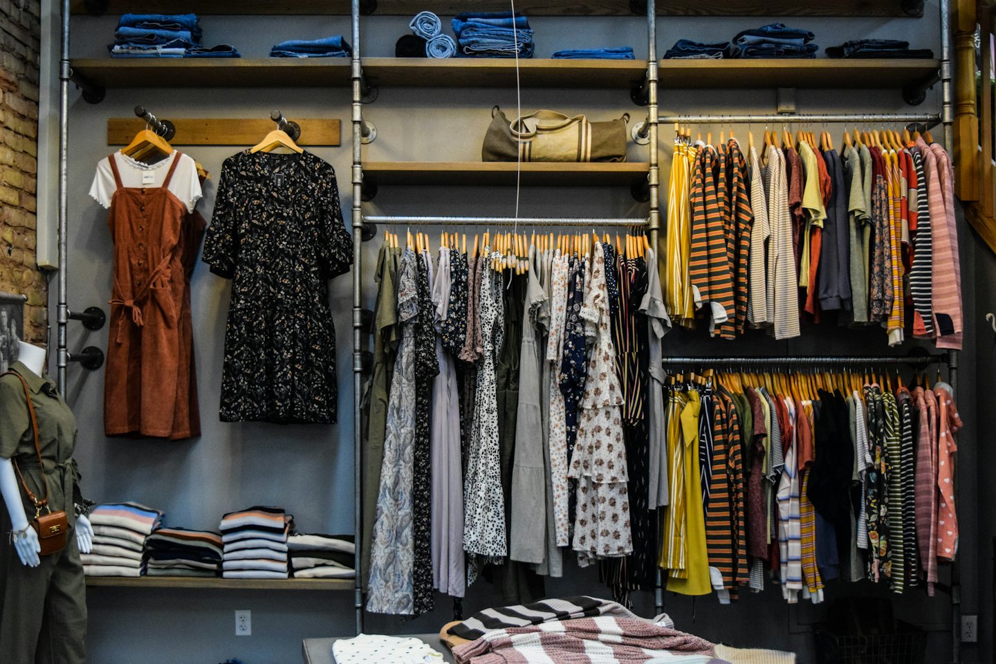 Boutique de ropa para mujer con vestidos y monos en exhibición.